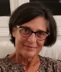 Bénédicte Charron, femme brune qui porte des lunettes de vue papillon et qui sourit chaleureusement.